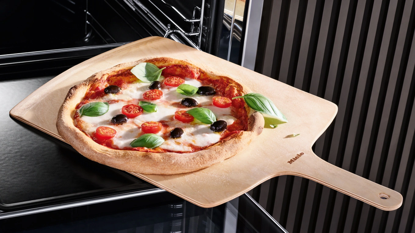 Miele pizza auf einem holzschieber