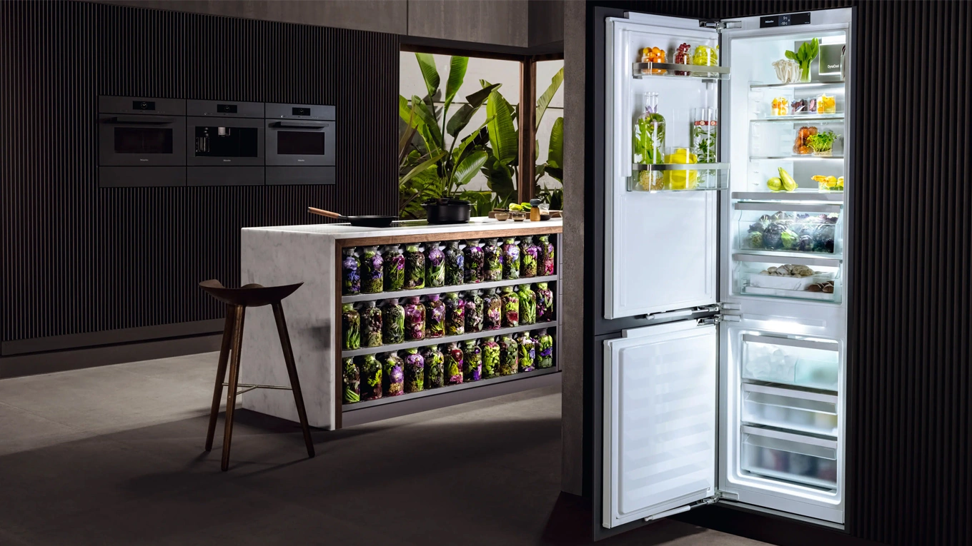miele neuheiten 2022 Geöffnete Miele Kühl-Gefrierkombination von 2022 in einer modernen küche bei nacht