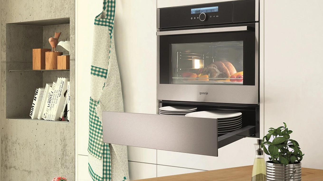 Gorenje Wärmeschublade Geöffnete Wärmeschublade in silber beim teller vorwärmen unter einem gorenje einbau backofen beim garen von lebensmitteln
