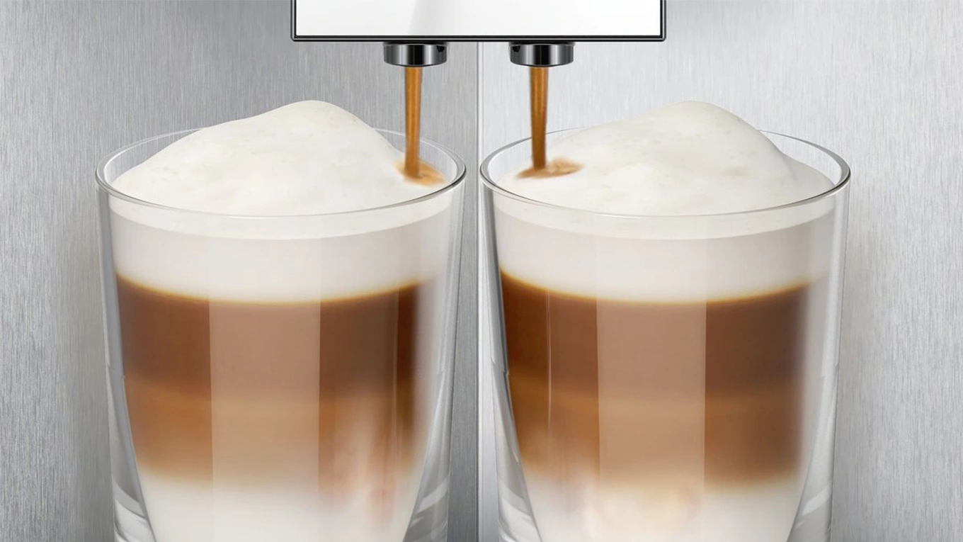 detailaufnahme vom siemens studioline einbau kaffeevollautomat beim brühen von latte macchiato in zwei gläser