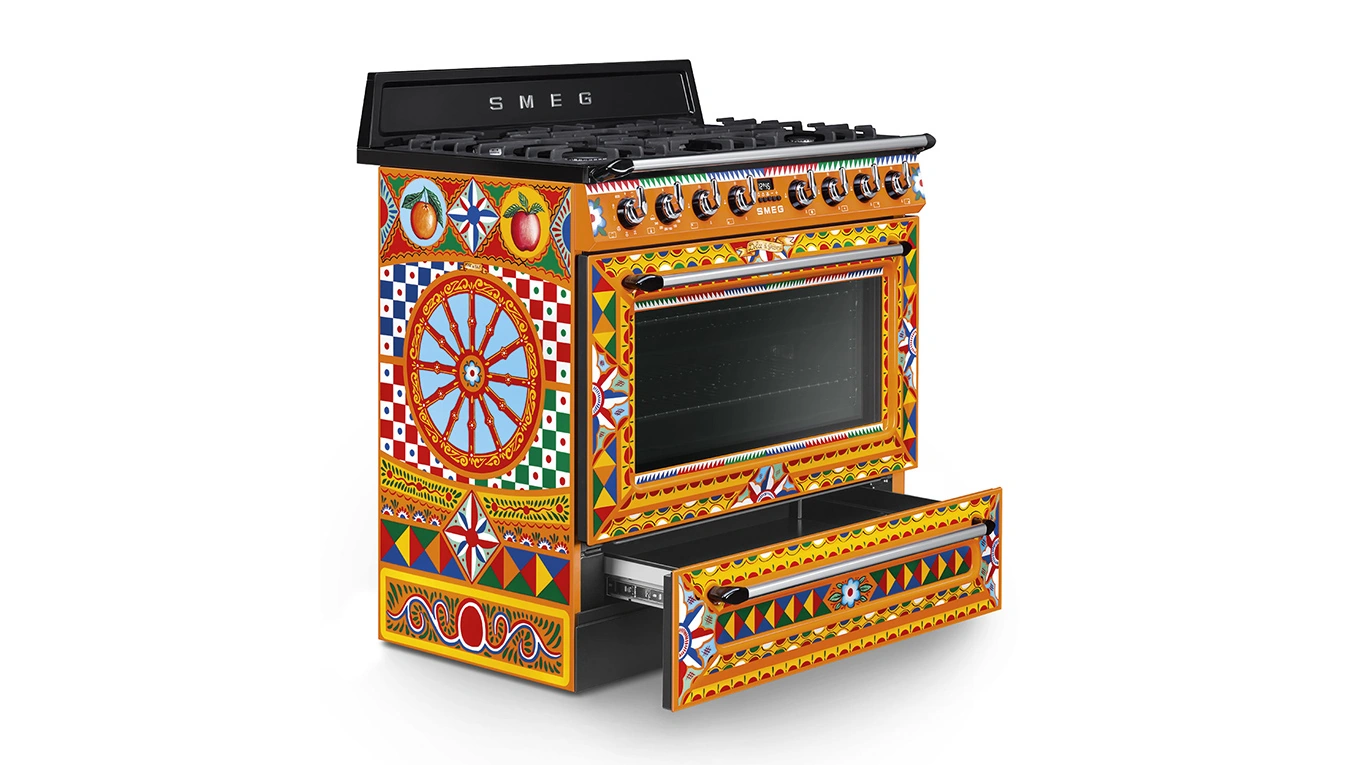 SMEG Dolce & Gabbana Sizilien Gas-Standherd produktbild vom smeg dolce gabbana gas standherd in orange rot von der seite mit geöffneter schublade