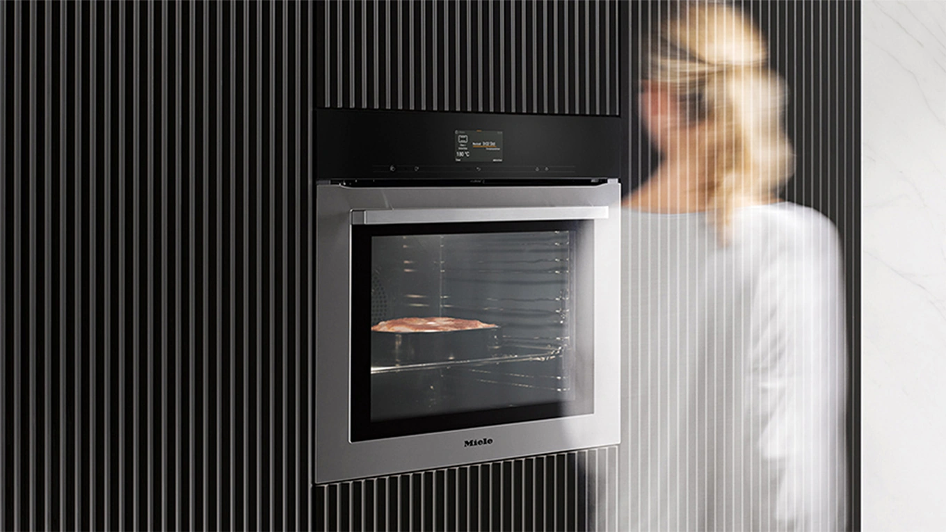 miele backofen generation 7000 mit motion react mit einer unscharfen frau im vorbeigehen davor