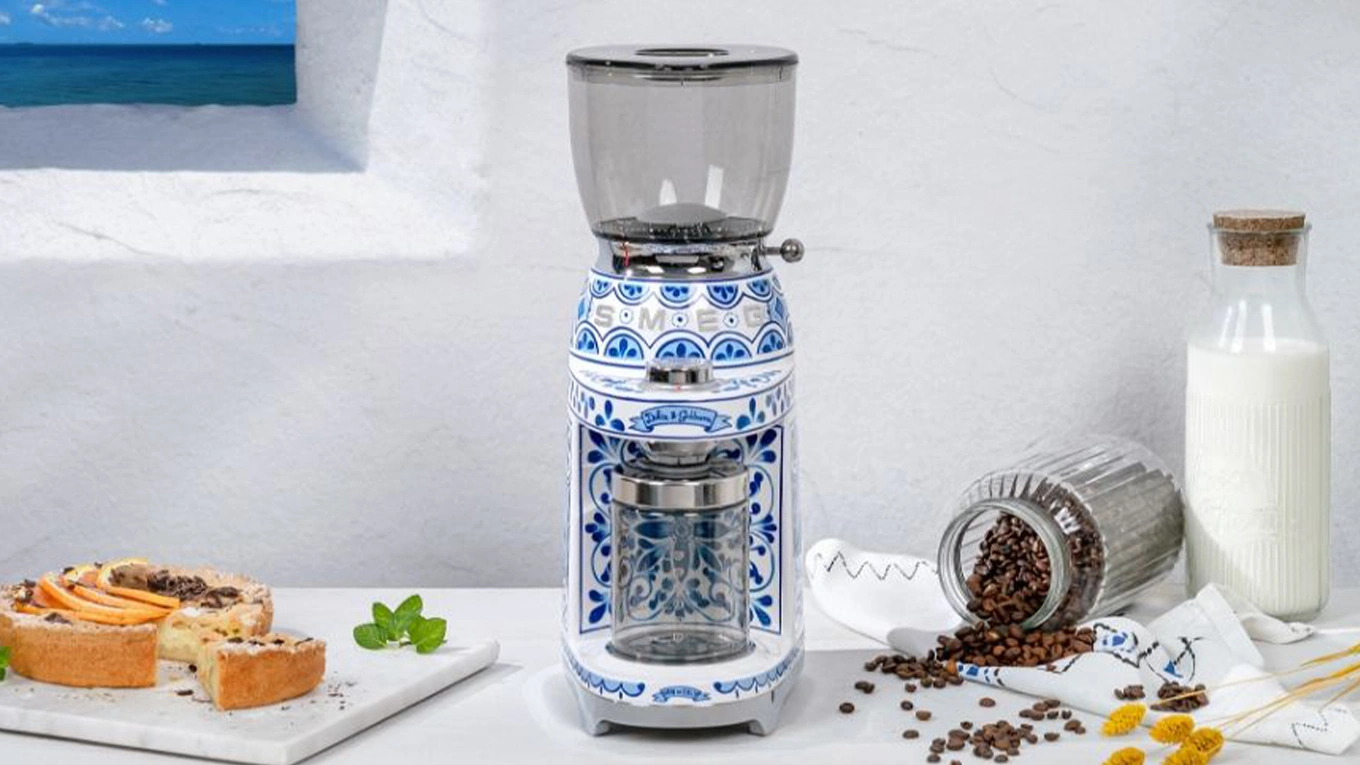 smeg dolce & gabbana blue mediterraneo kaffeemühle neben kaffeebohnen und kuchen