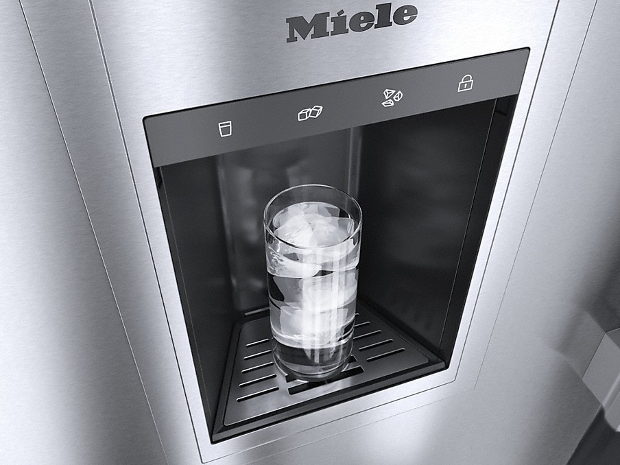 glas mit wasser und eiswürfeln unter einem ice water dispenser bei einem miele kühlschrank in silber