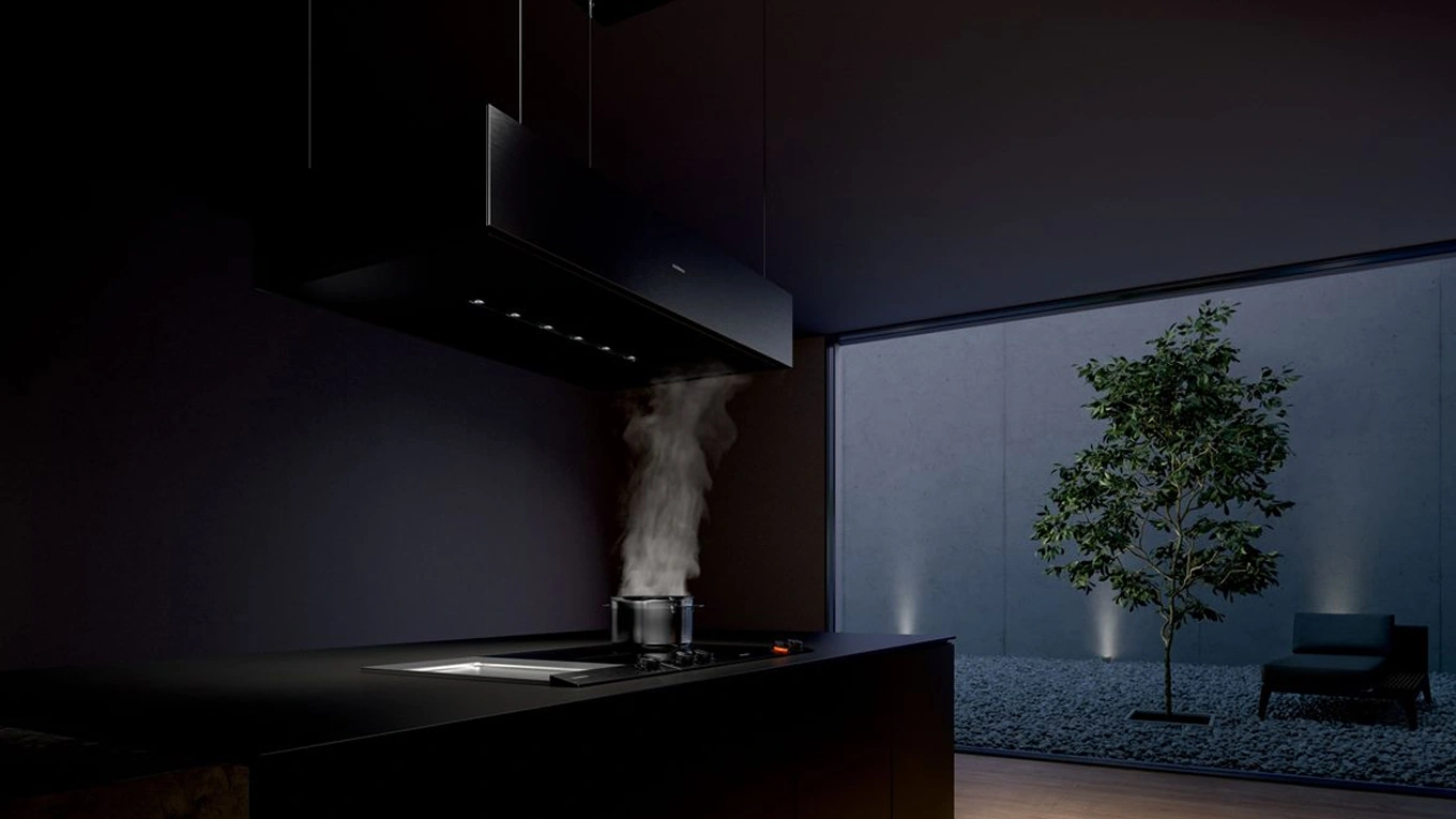Gaggenau Deckenlifthaube Serie 200 gaggenau deckenlifthaube aus der serie 200 über dem Kochfeld in einer dunklen Küche bei Nacht