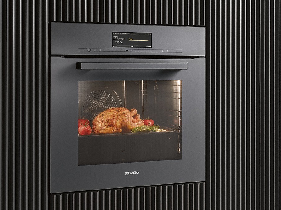 Miele kühle Backofentür dunkler miele backofen mit kühler front in einer gestreiften küchenfront mit hühnchen im backraum