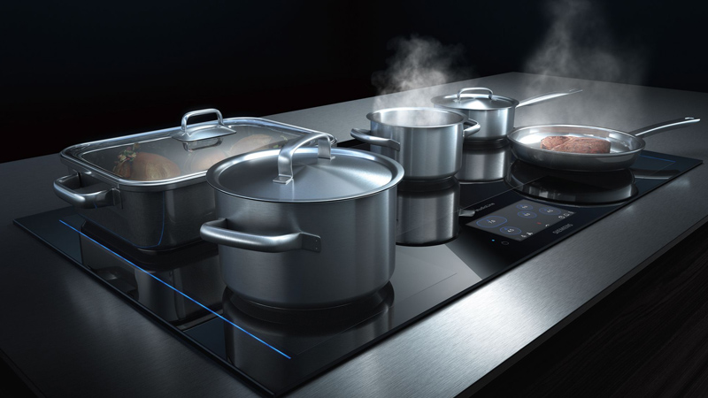 Siemens studioLine Kochfelder siemens studioline induktionskochfeld mit tft touch display auf dem viele edelstahltöpfe bräter und eine pfanne mit dampf kochen