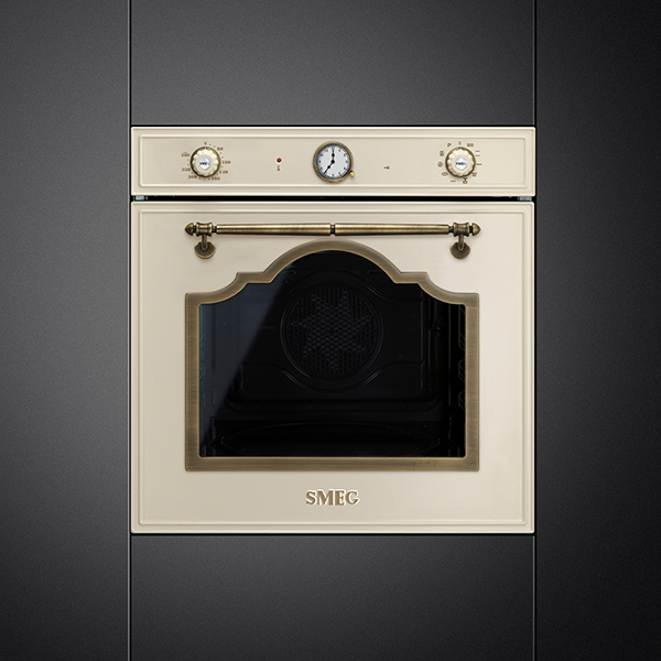 smeg retro einbau backofen in creme mit griff und bedienung in gold in einer schwarzen küchenfront