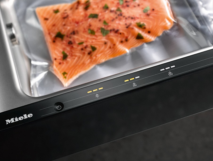 Sensor Touch Bedienung an einer Miele Vakuumierschublade mit vakuumiertem Lachs