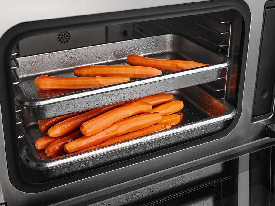 Miele unabhängiges Garen geschälte möhren auf zwei übereinander liegenden dampfgarbehälter in einem miele dampfgarer