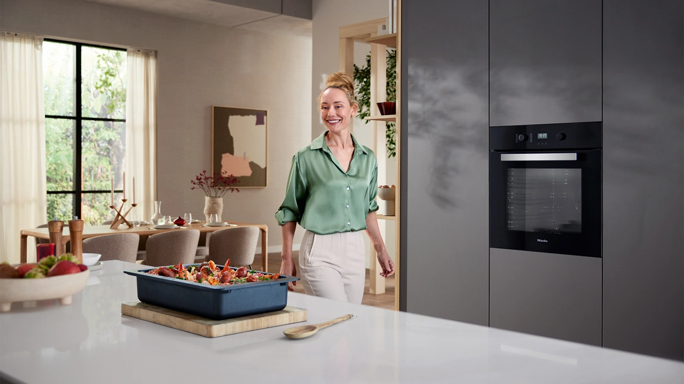 miele backofen zum einstiegspreis blonde frau vor einem miele backofen in obsidianschwarz zum einstiegspreis
