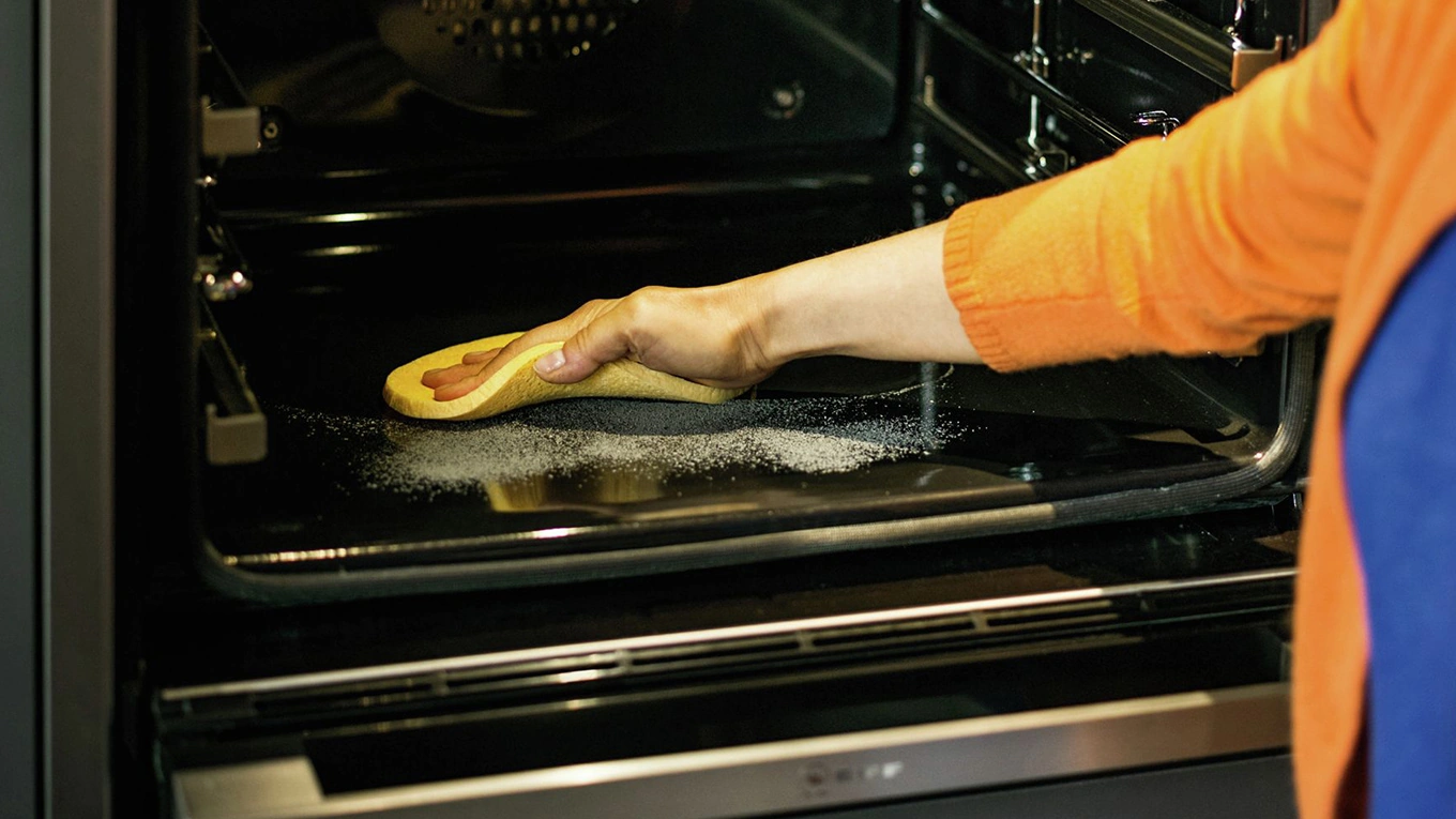 Backofen Reinigung mit einem gelben Lappen