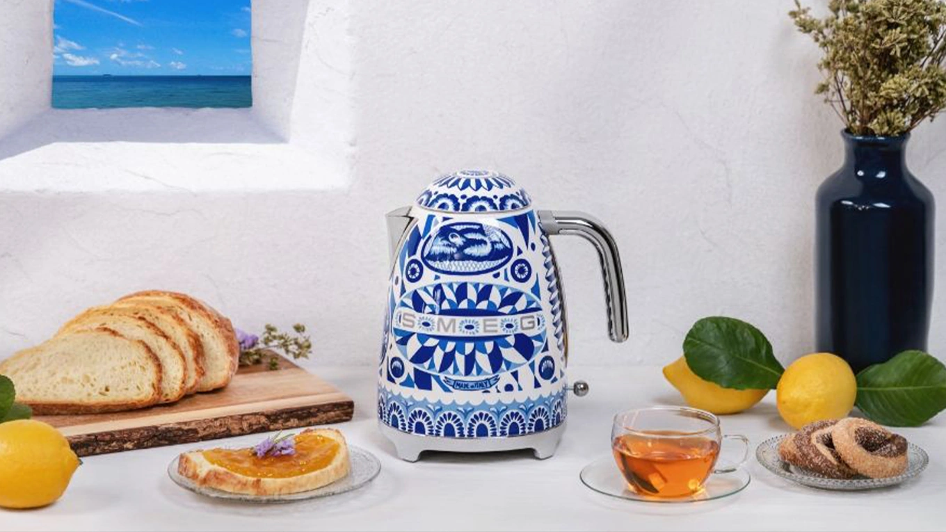 smeg dolce & gabbana blue mediterraneo wasserkocher mit kalkfilter smeg dolce & gabbana blue mediterraneo wasserkocher in blau weiß retro look neben einer teetasse und brot