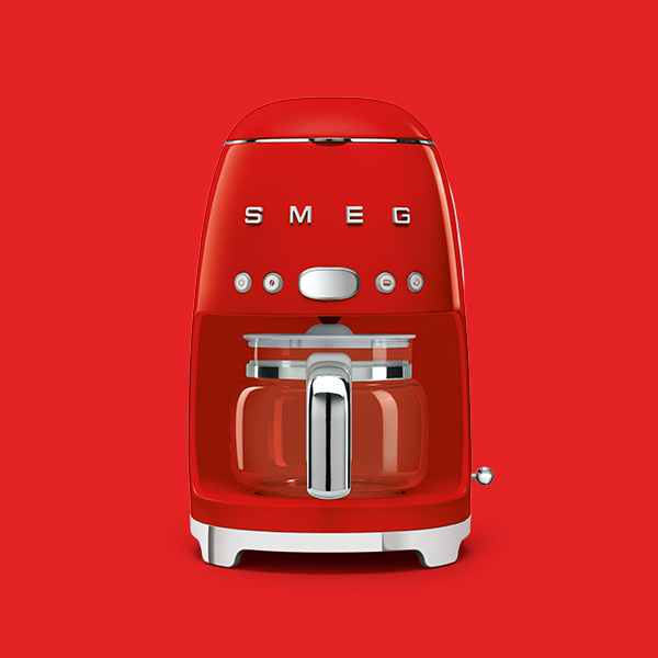 rote retro filterkaffeemaschine von smeg vor rotem hintergrund