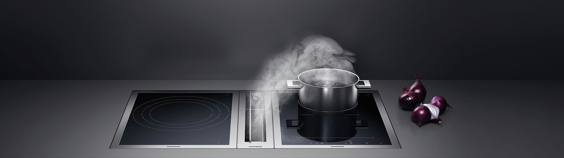gaggenau kochfeldabzug beim absaugen von wasserdampf auf einem topf in einer dunklen kulisse