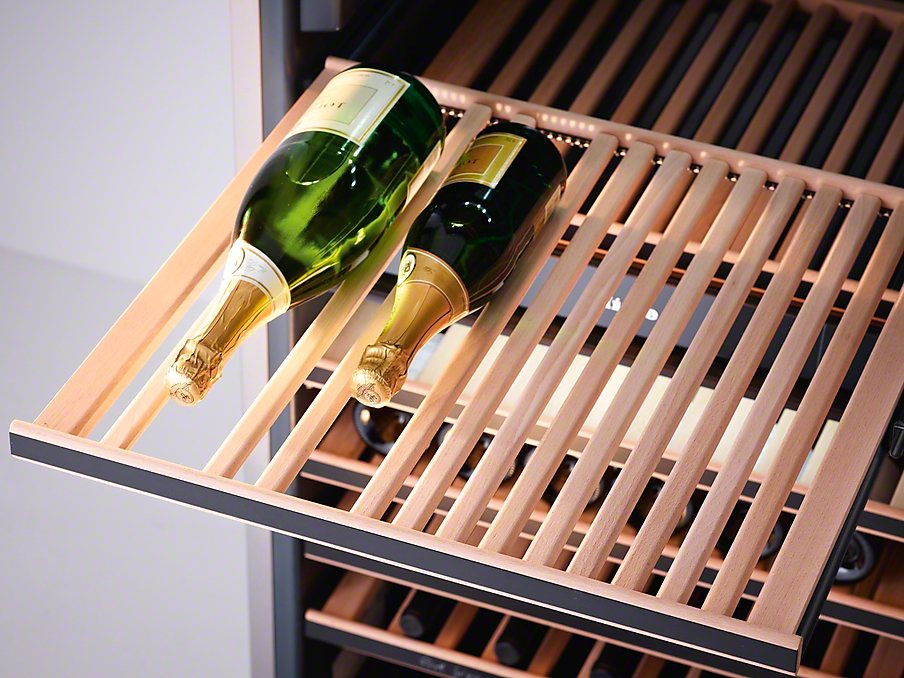 Miele Flexiframe Weinkühlschrank zwei liegende champagner flaschen auf einem herausgezogenen miele flexiframe holzrost im weinkühlschrank