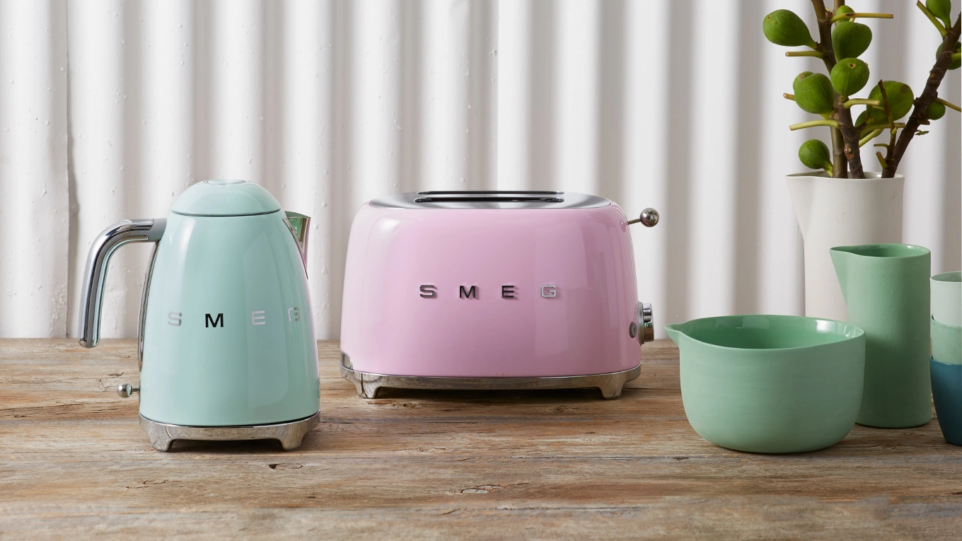 SMEG Kleingeräte in Pastellfarben smeg wasserkocher und toaster in blau und pink auf einer arbeitsplatte neben vasen
