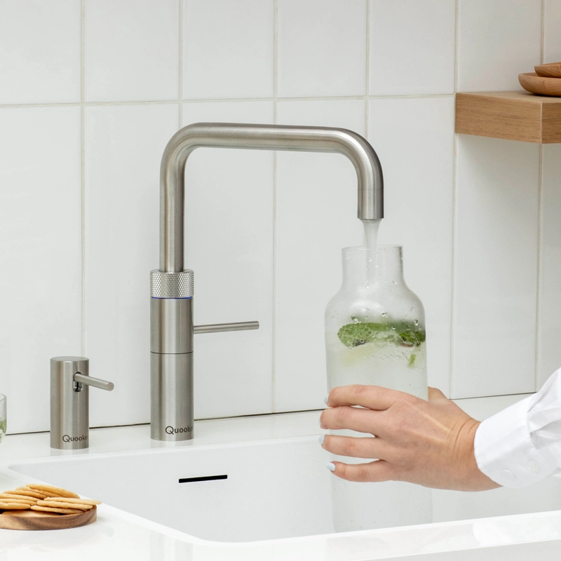 eckiger quooker hahn befüllt eine glasvase mit wasser