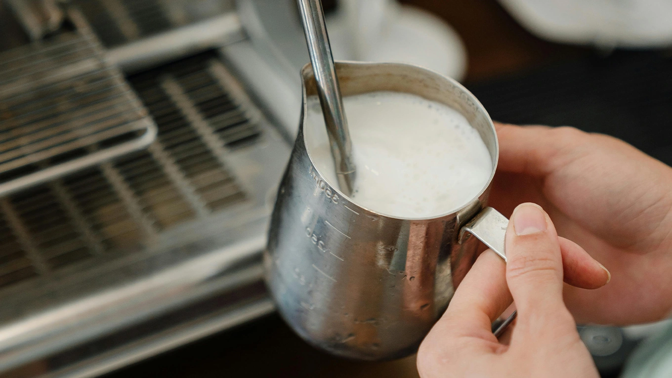 milch aufschäumen mittels dampf milch wird in einem kännchen mittels dampflanze am siebträger erhitzt