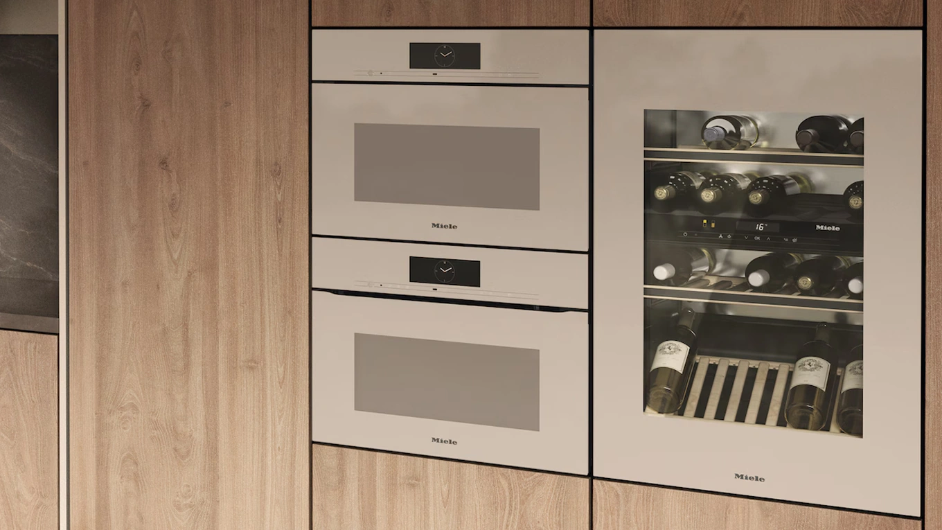 drei miele einbaugeräte in pearlbeige in einer holzfront
