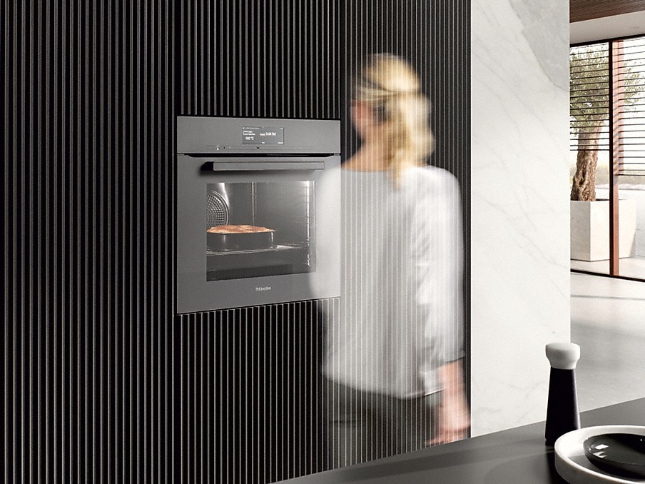 Miele Motionreact unscharfe Frau im vorbeilaufen an einem einbau-backofen von miele mit motionreact