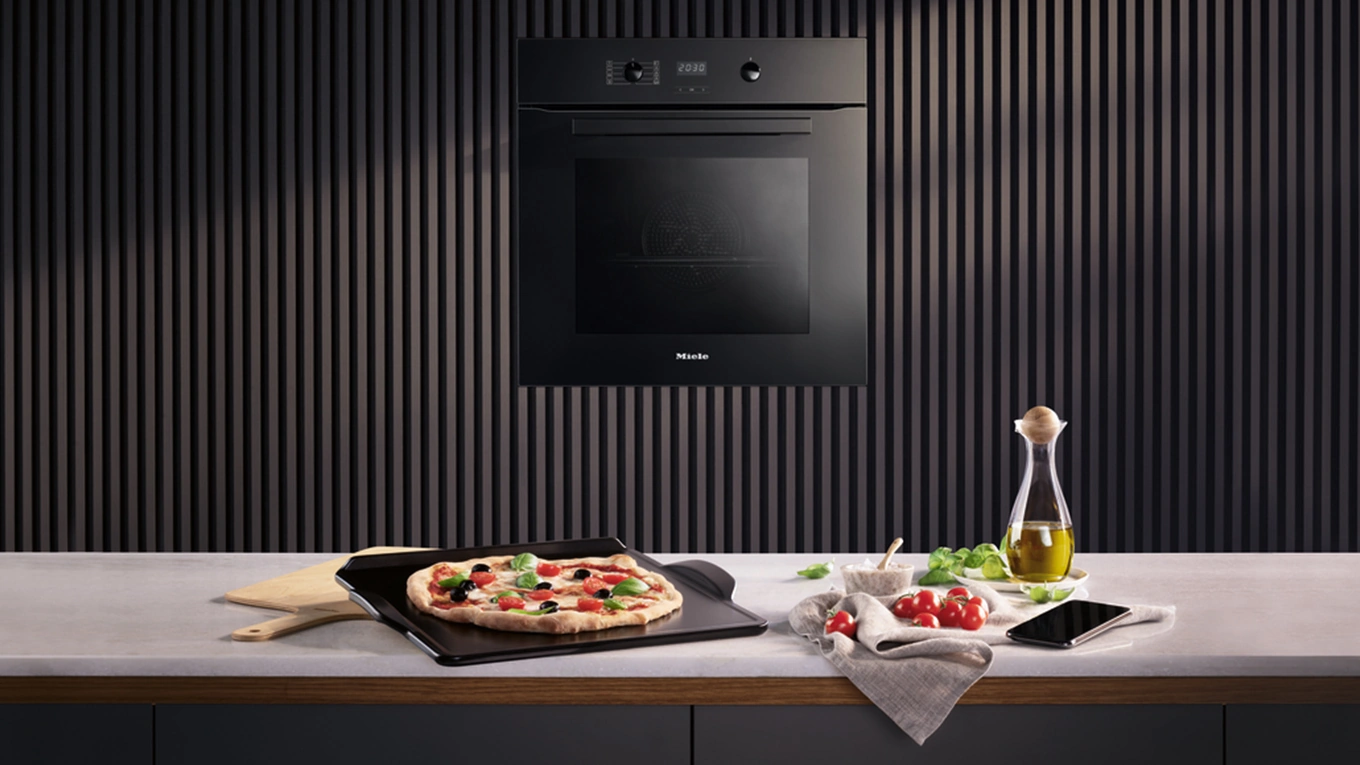 pizza auf dem miele backstein auf einer arbeitsplatte vor dem miele pizzaplus backofen