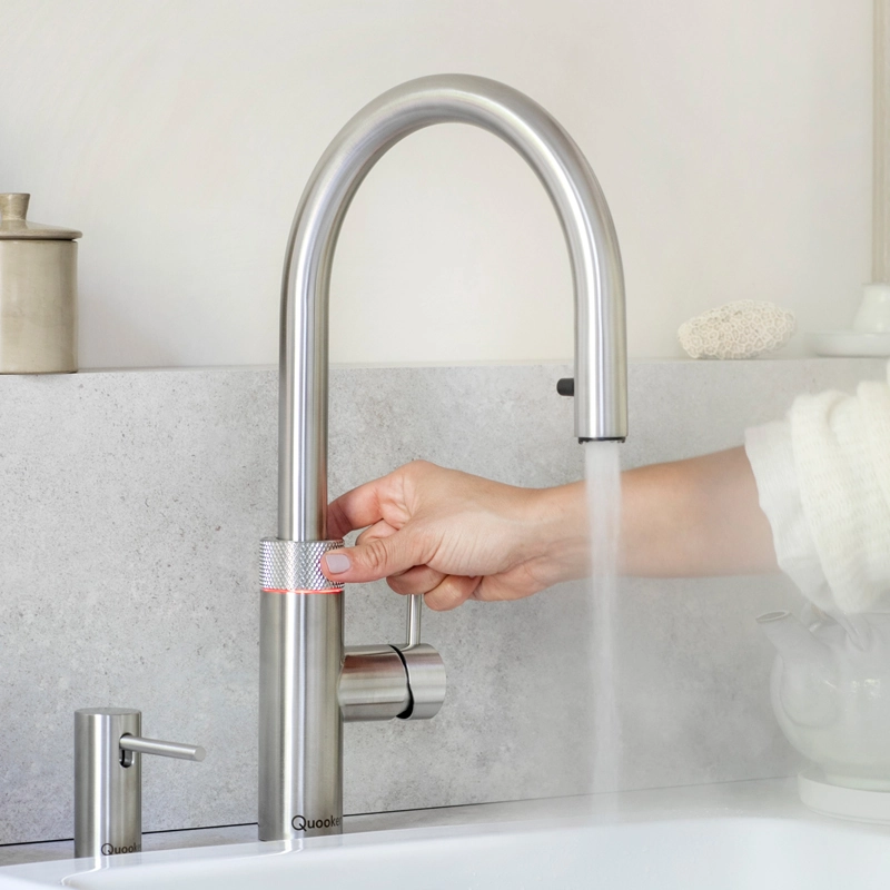 kochend heißes wasser fließt aus einem quooker wasserhahn aus edelstahl in runder form