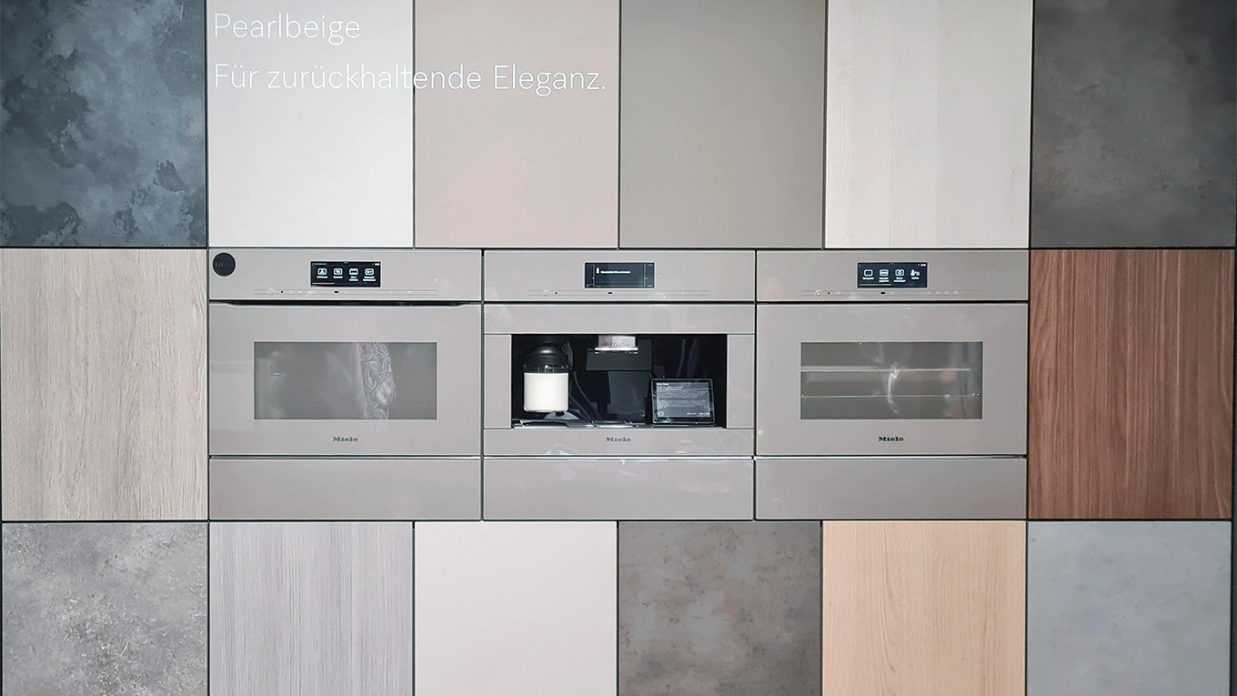 Miele pearlbeige einbaugeräte in einer einbaunische mit vielen verschiedenen miele farben und oberflächen