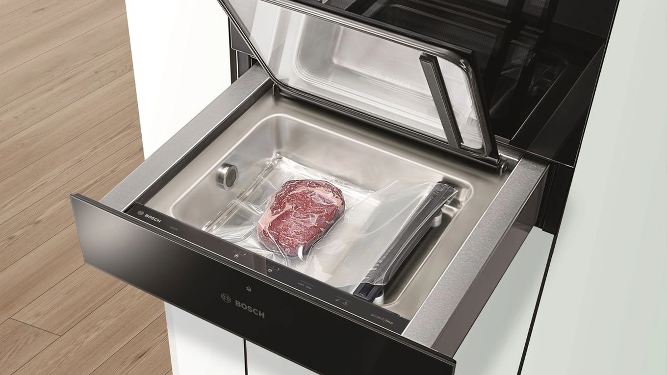 Bosch Vakuumierschublade geöffnete klappe bei der bosch vakuumierschublade mit einem vakuumiertem stück fleisch