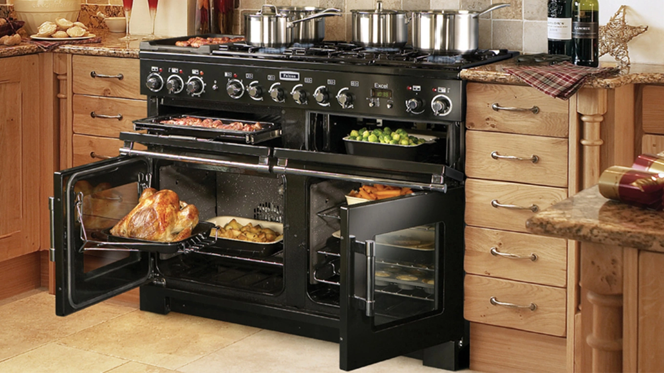 falcon range cooker in schwarz mit geöffneten Backofentüren in einer Holzküche