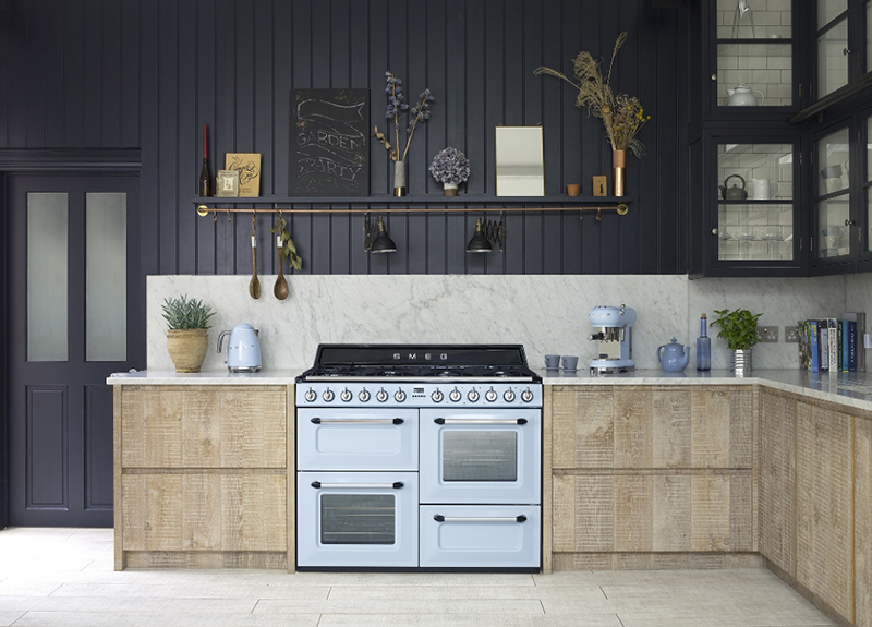 SMEG 50er Jahre Pastellblauer SMEG Standherd im 50er Jahre retro stil in einer l-eckküche mit griffloser holzfront und schwarzer wand