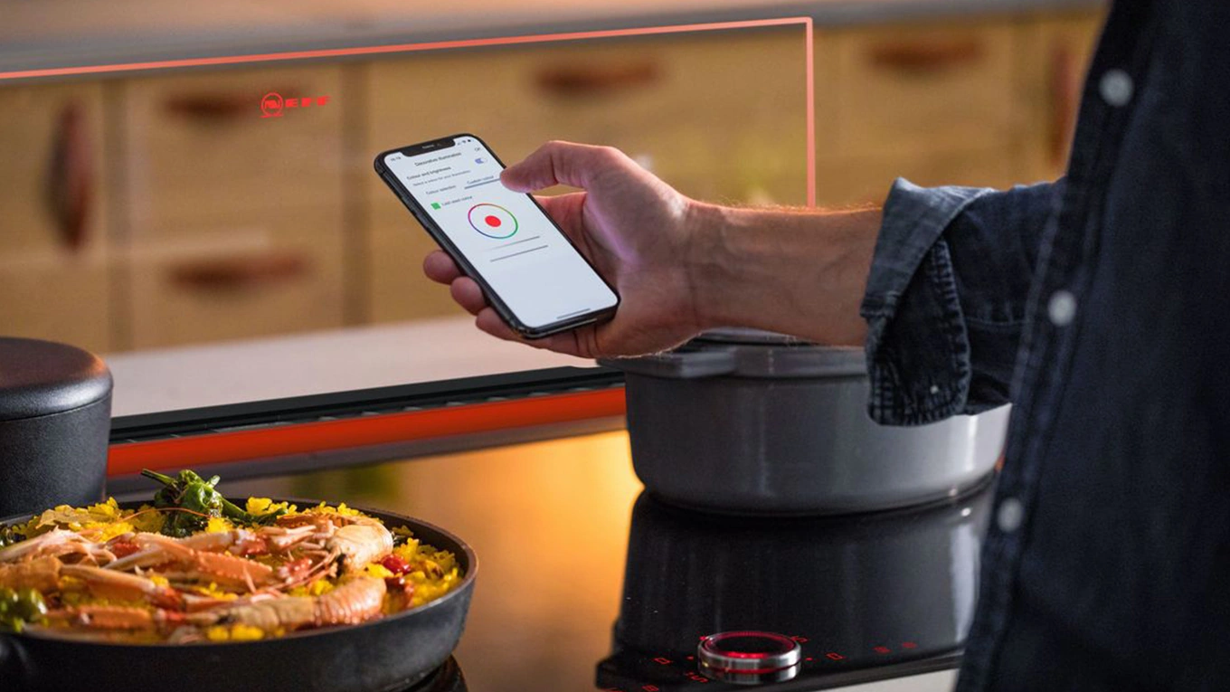 Neff Glas Tischlüfter mit LED-Licht in Rot Smartphone beim Einstellen von rotem LED-Licht am Neff Glas Tischlüfter