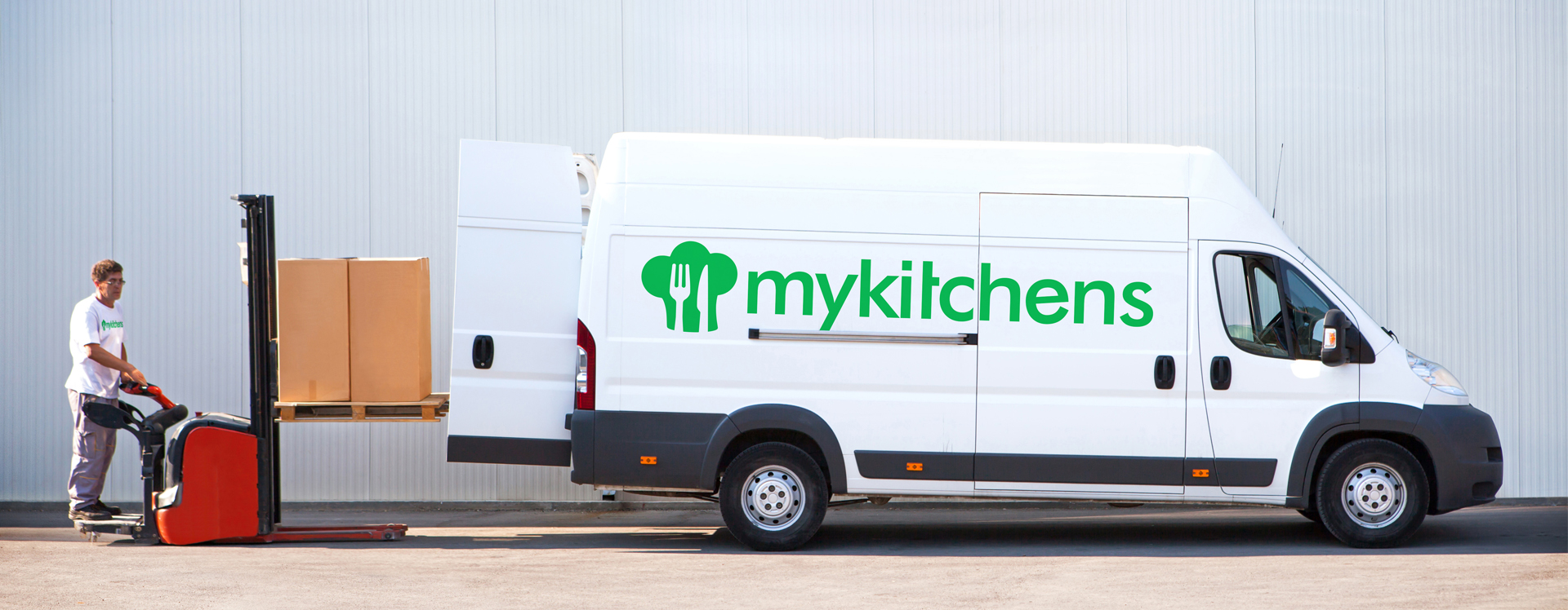 Mykitchens Lieferung Mann beim Einladen von paketen in einen weißen Van mit Mykitchens logo