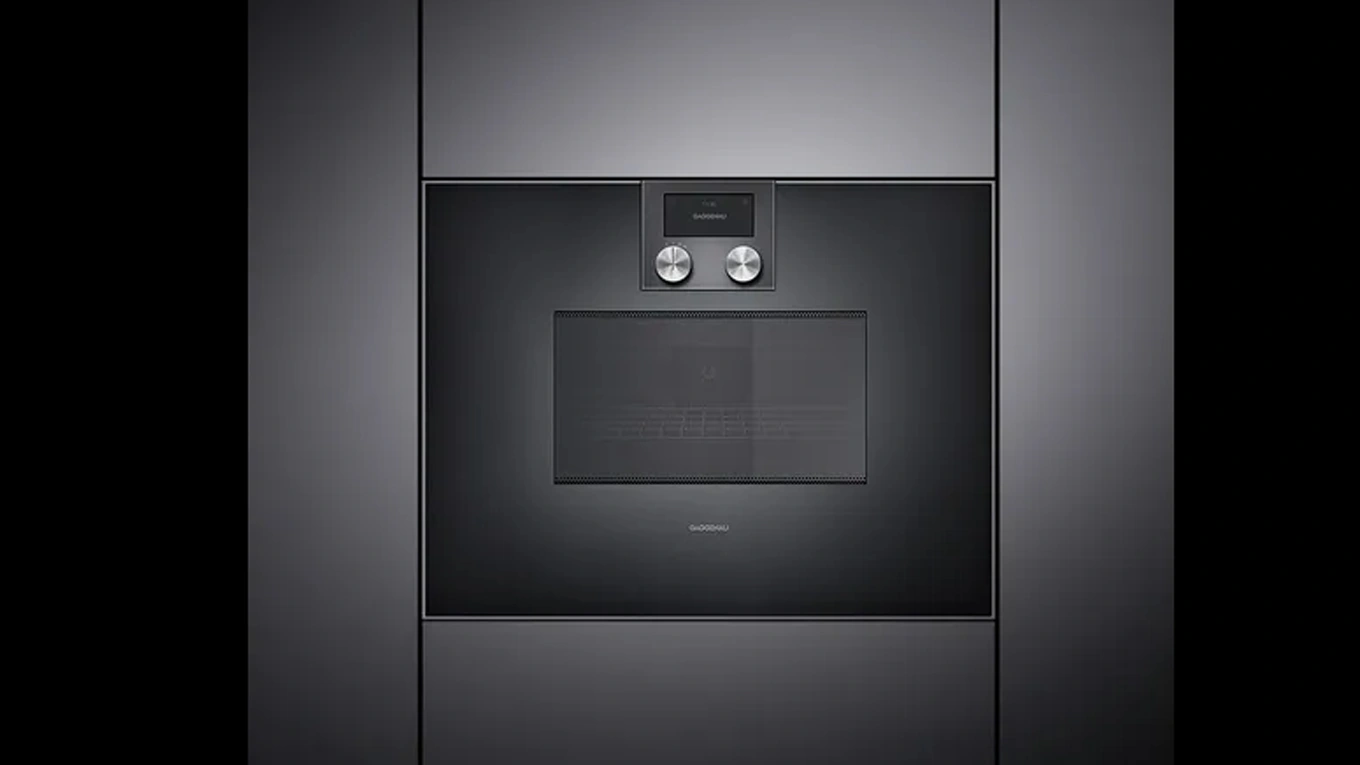 Schwarzer Mikrowellen Backofen aus der Gaggenau Serie 400 eingebaut in einer dunklen Küchenfront