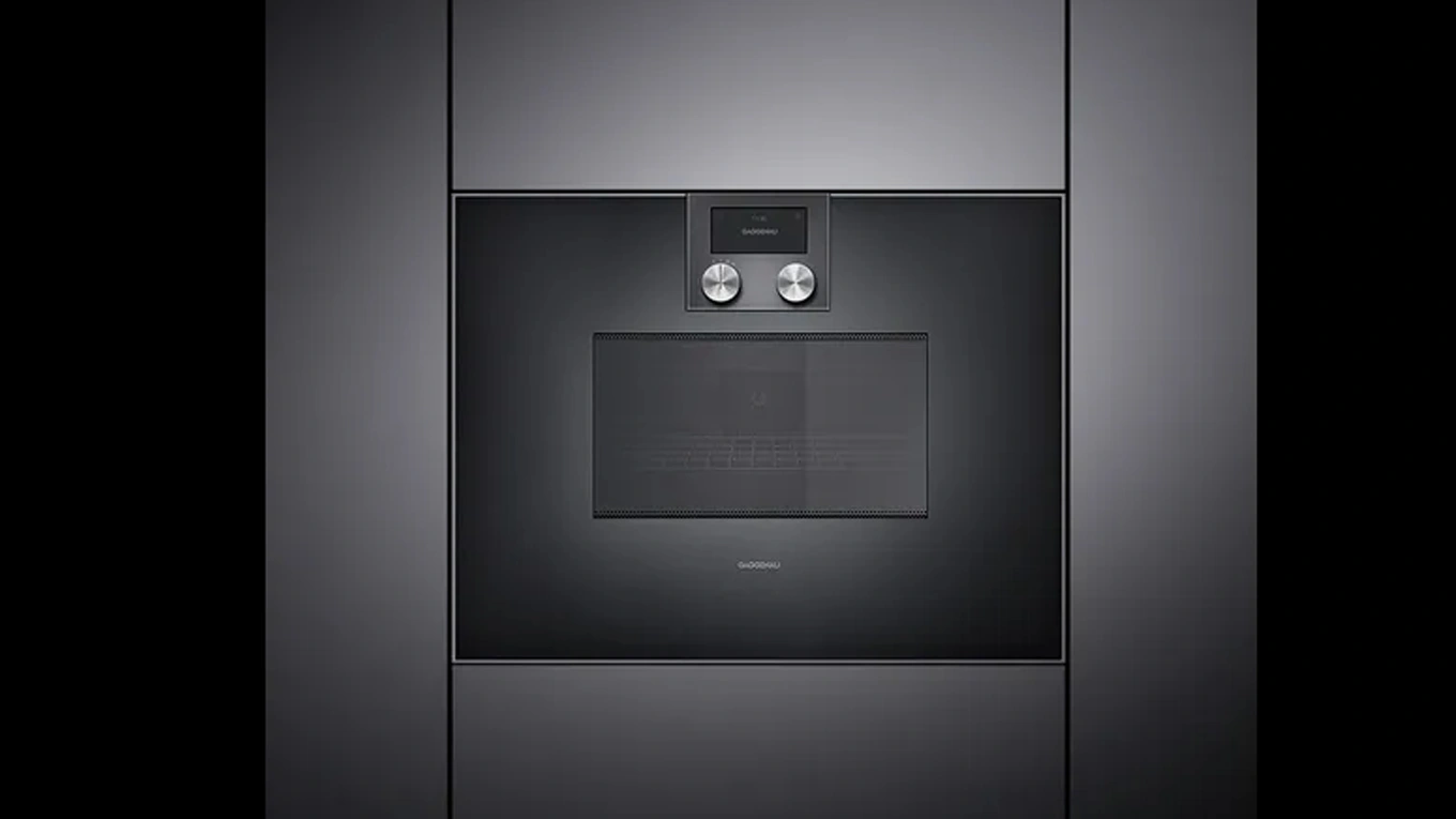 Gaggenau Serie 400 Mikrowellen Backofen Schwarzer Mikrowellen Backofen aus der Gaggenau Serie 400 eingebaut in einer dunklen Küchenfront