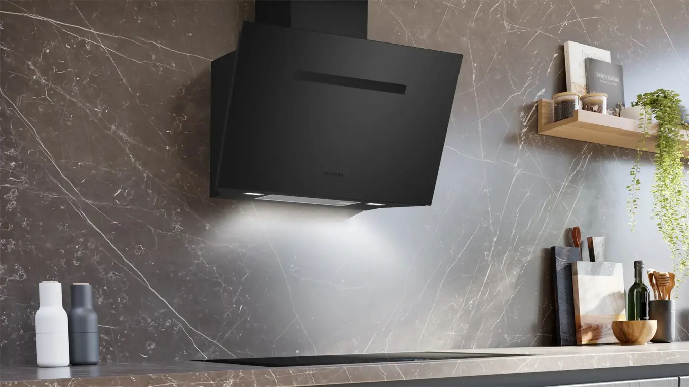 Siemens Kopffreihaube in mattschwarz über einem kochfeld in einer steinküche