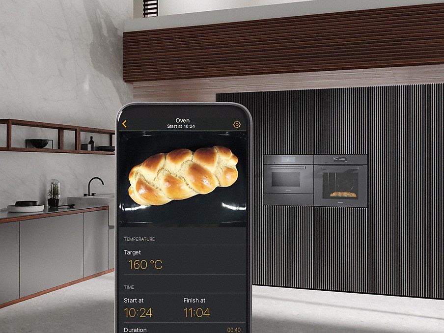 Miele Foodview hefezopf mit garangaben auf dem display eines smartphones mit miele app vor einem miele einbau-backofen mit foodview