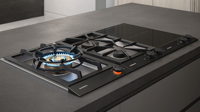 ein gaggenau serie 200 vario gas kochfeld bei dem der erste brenner blau leuchtet