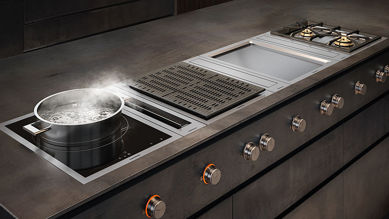 Gaggenau Serie 400 Vario Kochfelder ein gaggenau serie 400 vario kochfeld mit induktionsplatte auf der wasser in einem edelstahl kochtopf kocht daneben ein kochfeldabzug teppan yaku und gas