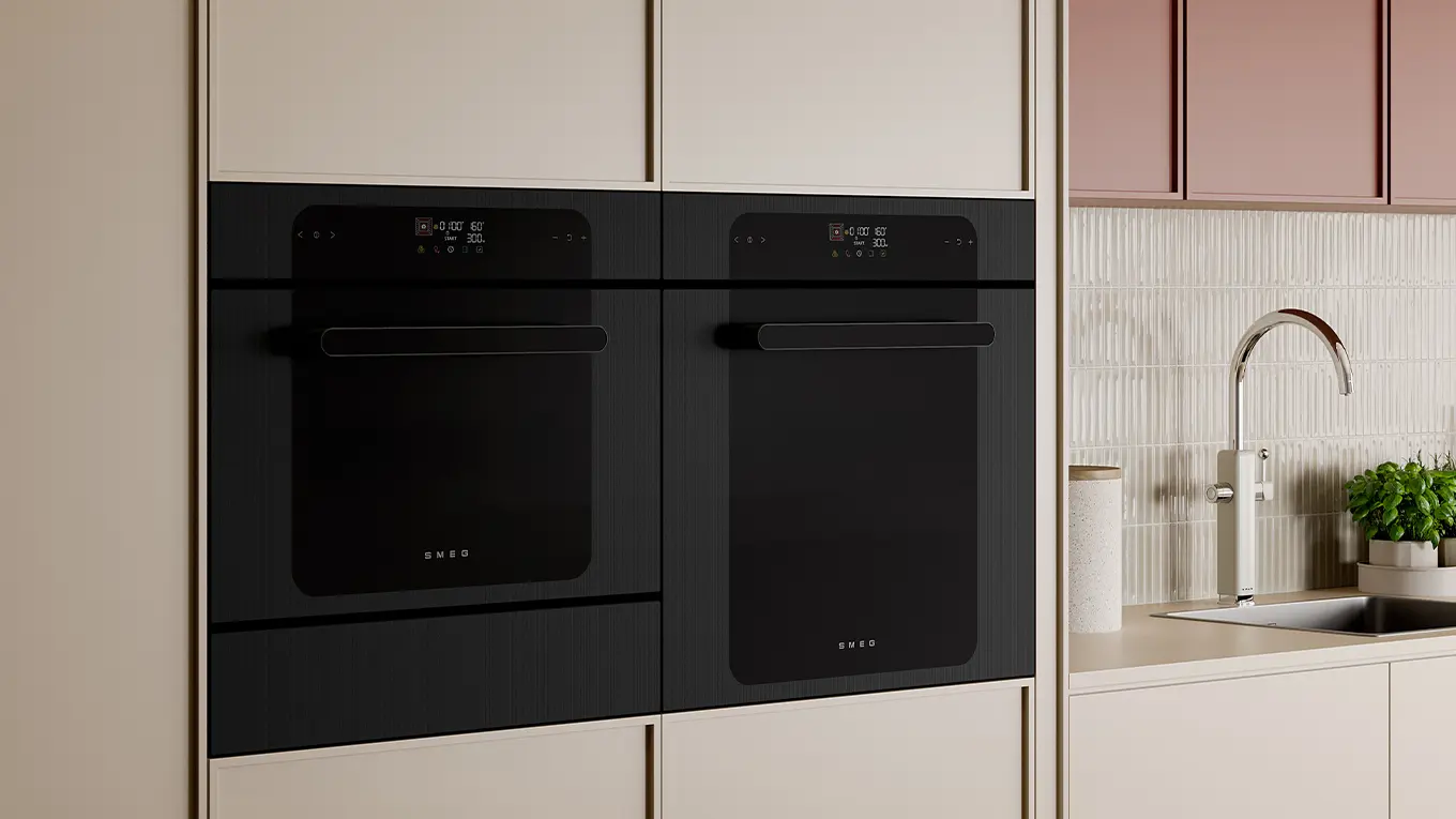 Zwei Smeg Backöfen nebneinander in einer creme küche