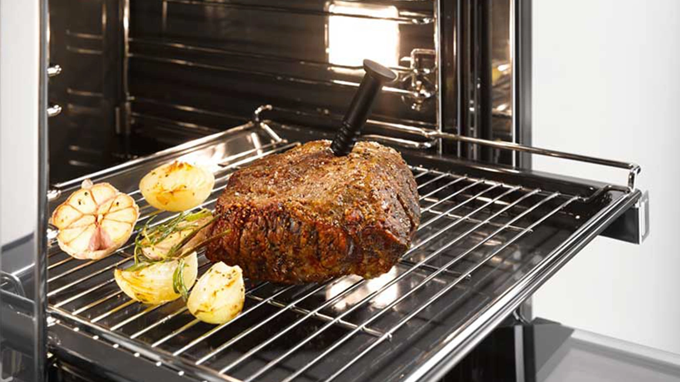 fleischstück auf einem rost mit darin steckendem speisenthermometer in einem miele backofen