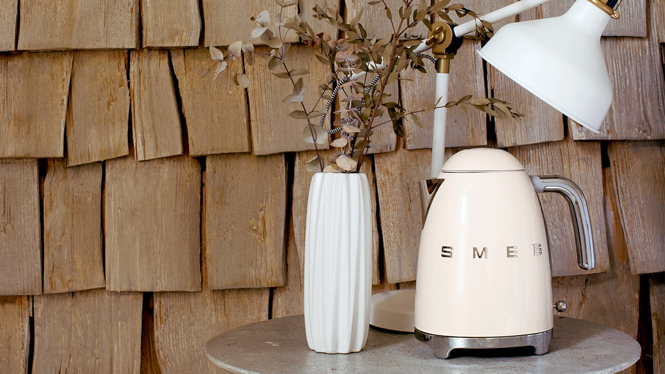 smeg beige wasserkocher auf einem beistelltisch neben einer weißen vase