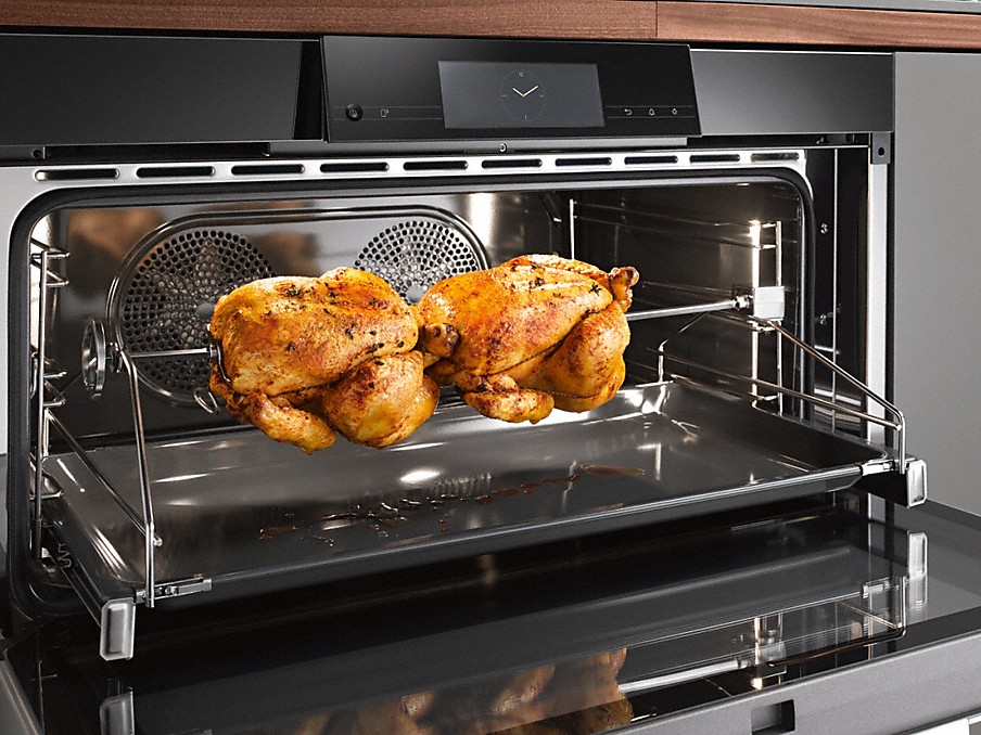 Miele Drehgrilleinrichtung zwei huehnchen auf einer drehgrilleinrichtung in einem miele backofen