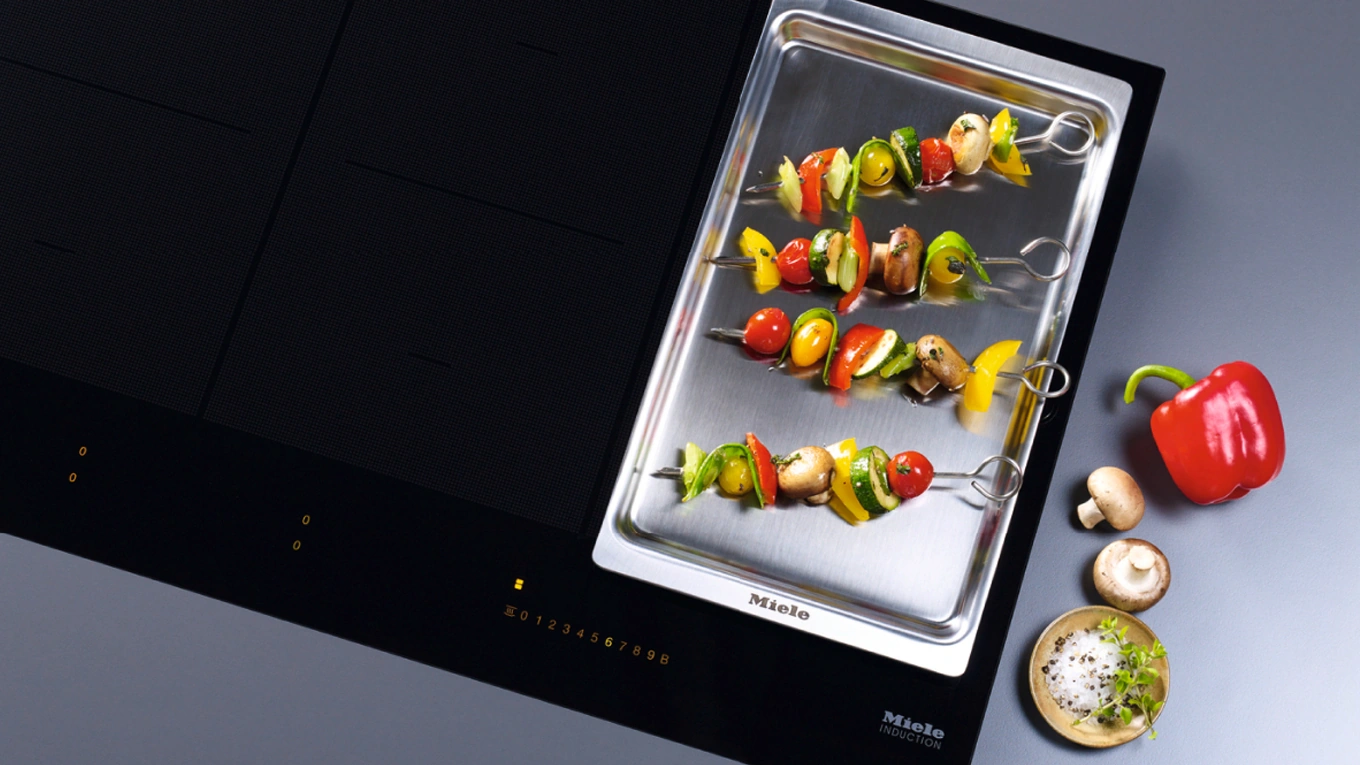 Miele KMTY Teppan Yaki für Induktionskochfeld Miele KMTY Teppan Yaki Edelstahlgrill mit Gemüse Grill spießen auf einem Induktionskochfeld