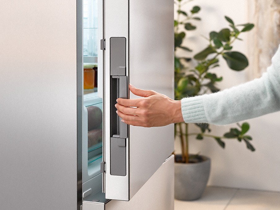 Miele Click2open Kühlschrank hand beim öffnen einer miele click2open kühlschranktür in edelstahl