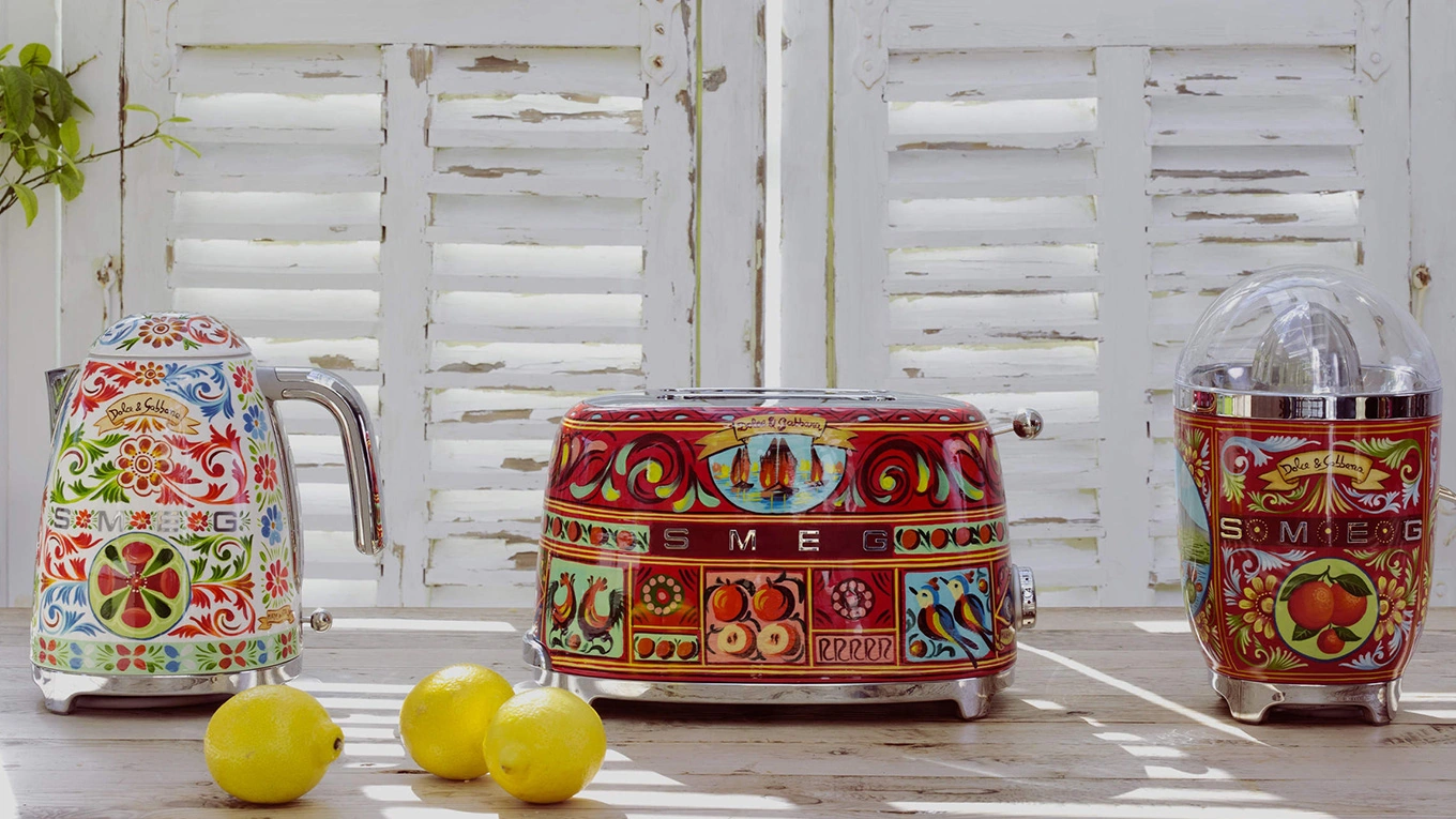 toaster wasserkocher und saftpresse aus der smeg dolce und gabbana kollektion sicily is my love mit drei zitronen in einer mediterranen küche