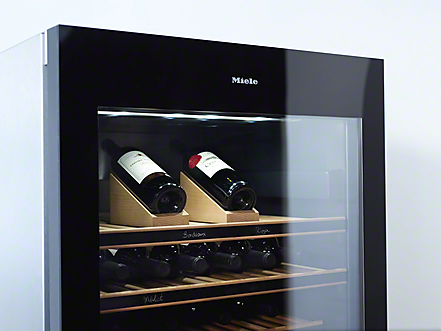 Miele UV-Schutz Weinkühlschrank oberer teil von einem miele weinkühlschrank mit uv schutz in dem zwei flaschen auf dem selector holz presenter liegen
