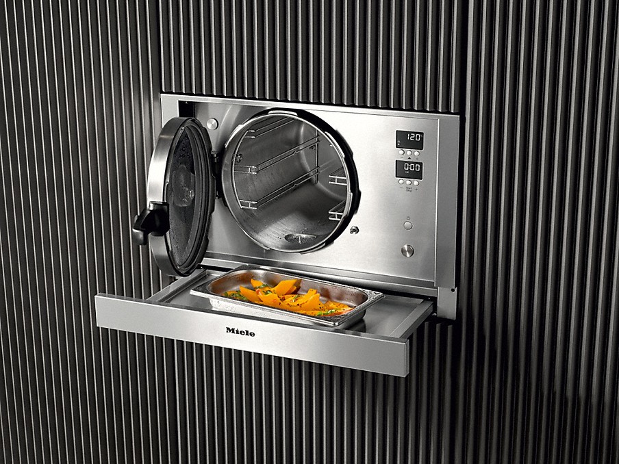 Miele ausziehbare Stellfläche edelstahlbehaelter mit lebensmitteln auf einer ausziehbaren miele stellflaeche unterm dampfgarer