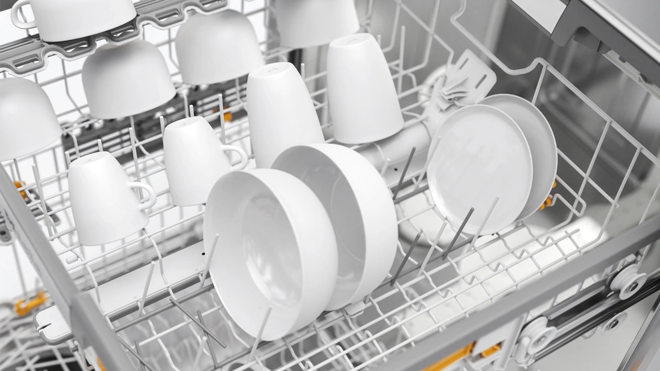 miele korbgestaltung beim geschirrspüler Geschirrspülerkörbe im Detail mit weißen Schalen und Tassen in einem Miele Geschirrspüler