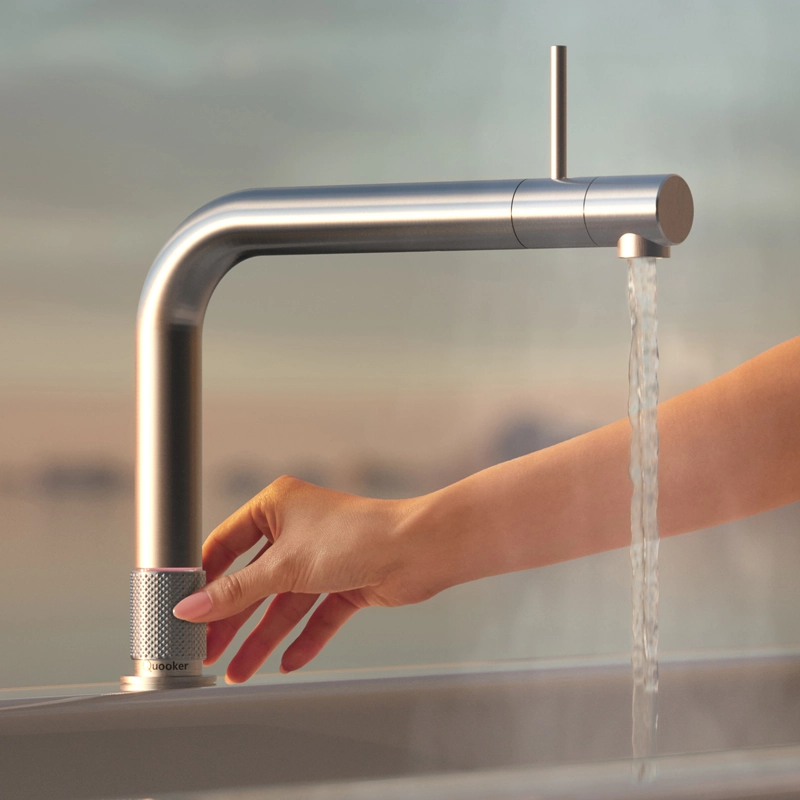 kochend heißes wasser fließt aus einem quooker wasserhahn aus edelstahl in modernen form